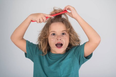 Photo for Child combing hair after shower. Child with curly hair hold hairbrush or comb. Healthy hair. Kid brushing unruly tangled hair - Royalty Free Image