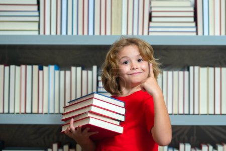 Photo for School kid with pile of books. Children enjoying book story in school library. Kids imagination, interest to literature. Kids smart activity. Child study read book in classroom - Royalty Free Image
