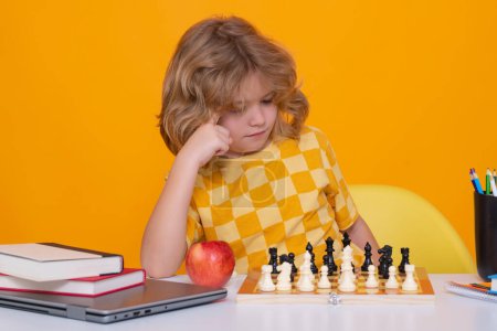 Photo for Chess school. Child think about chess game. Intelligent, smart and clever school kid pupil. Games for brain intelligence concept. Little chess player on yellow isolated studio background - Royalty Free Image