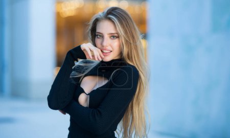 Téléchargez les photos : Modèle de mode avec de longs cheveux blonds posant en plein air. Portrait de haute couture de jeune femme élégante - en image libre de droit