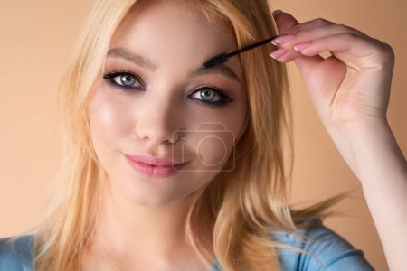 Téléchargez les photos : Perfect eyebrows. Natural beauty brows. Eyebrows coloring and lamination. Woman combing eyebrows. Makeup and cosmetology concept. Eyebrow shape modeling - en image libre de droit