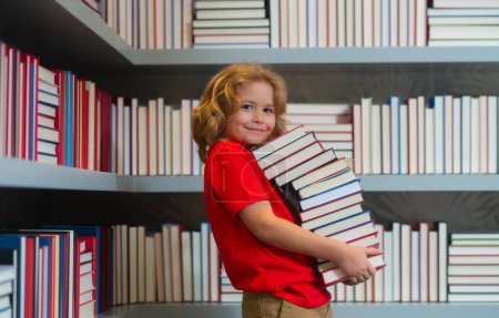 Photo for Knowledge day. School kid with pile of books. Children enjoying book story in school library. Kids imagination, interest to literature. Kids smart activity. Child study read book in classroom - Royalty Free Image
