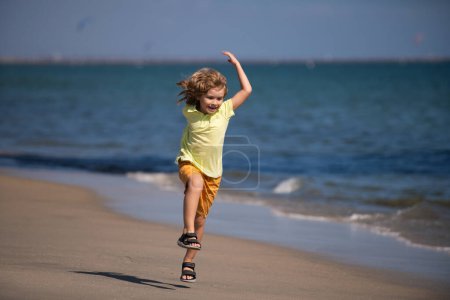Foto de Niño corriendo sobre la arena cerca de la playa. Carrera y deporte saludable para los niños. Niño corriendo en el parque de verano. Ejecutar entrenamiento al aire libre. Niños deportistas - Imagen libre de derechos