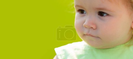Foto de Bebé en el campo de hierba de primavera, bandera. Retrato de niños, primer plano de la cabeza del bebé lindo niño - Imagen libre de derechos