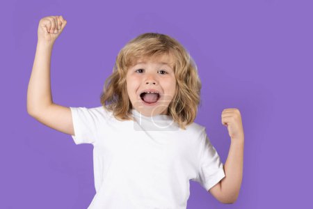 Photo for Excited kid boy celebrating victory on studio isolated background. Surprised kids face, amazed emotions of child. Rejoicing, yes gesture and success concept - Royalty Free Image