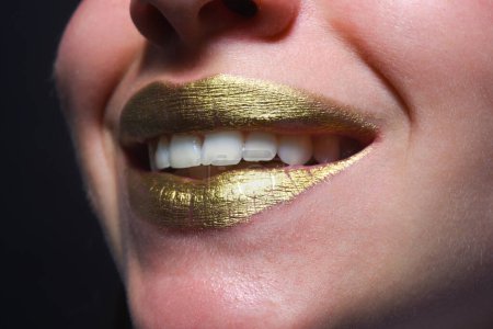 Photo for Close up woma face with gold lips. Gold paint on mouth. Golden lips. Luxury gold lips make-up. Golden lips with creative metallic lipstick. Gold metal lip. Sensual woman mouth, clse up, macro - Royalty Free Image