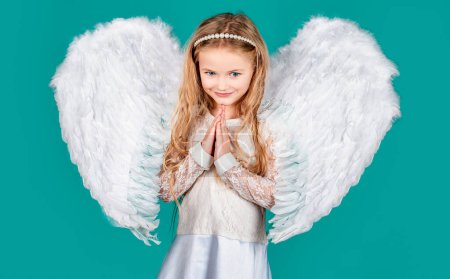 Photo for Child with angelic face. Cute child girl posing with angel wings. Beautiful little angel girl standing with your arms close to your chest as in prayer. Angel dream. Dreamy kids face. Daydreamer child - Royalty Free Image