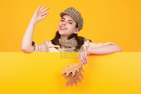 Photo for Beautiful woman in autumn clothes hold falling leaves posing in studio. Gorgeous brunette model girl with yellow autumn maple leaf. Autumn woman in studio. Autumnal mood - Royalty Free Image