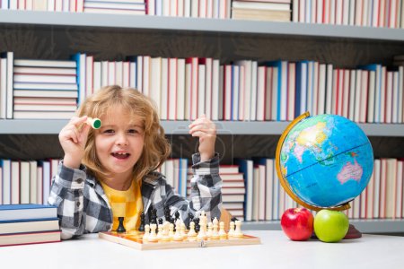 Photo for Kid play chess at school. Chess school. Child think about chess game. Intelligent, smart and clever school kid pupil. Games for brain intelligence concept - Royalty Free Image