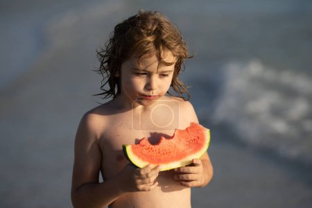Photo for Child with watermelon on summer beach outdoor. Kid having fun in summer day. Kids summer vacation and healthy eating. Kittle kid eats juicy watermelon on the beach, coast, seashore. Summer fruits - Royalty Free Image