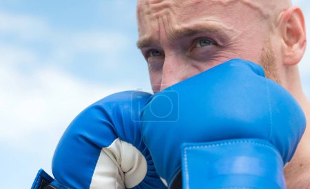 Photo for Kick boxer or muay thai fighter punching. Kickboxing fighter in boxing gloves hitting shadow, training for competition. Man face close up in boxing - Royalty Free Image