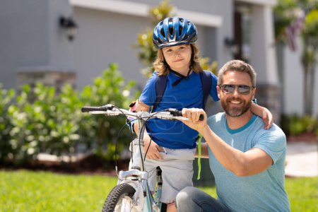 Photo for Fathers day. Happy family, men generations. Concept of friendly family and summer lifestyle. Father and son riding a bike in american neighborhood. Parents and children friends. Child first bike - Royalty Free Image