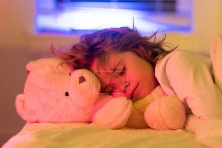 Photo for Night sleep. Child boy sleep, napping. Kid sleeping in bed with a toy teddy bear - Royalty Free Image