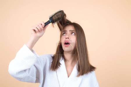 Photo for Sad girl with damaged hair. Haircare problem. Woman with hair loss problem. Portrait of young woman with a damaged bad hair. Girl with a hairbrush loosing hair. Hairs are tangled, frizzy and messy - Royalty Free Image