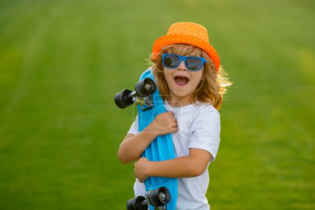 Téléchargez les photos : Enfant avec skateboard. Patins pour enfants. Sport et activité physique sains pour les écoliers en été. Du sport. Longboard, skateboard penny board concept - en image libre de droit