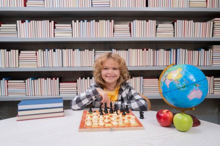 Photo for Child play chess in classroom at school. Clever concentrated and thinking kid playing chess. Kids brain development and logic game - Royalty Free Image