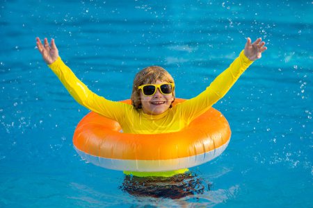 Photo for Little boy with rubber ring in swimming pool. Summertime fun. Little kid swimming in pool. Kid in swimming pool. Kid relax swim on inflatable ring. Summer vacation concept - Royalty Free Image
