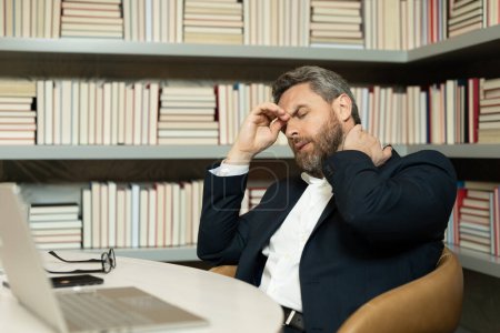 Photo for Overworked man feeling migraine head strain. Tired bored man has office syndrome. Exhausted man work on laptop struggle with migraine or headache. Office worker, manager freelancer having a headache - Royalty Free Image