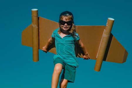Photo for Happy child running with paper wings. Kid dreams of future. Kid pilot dreaming. Childhood dream concept. Blonde cute daydreamer child dream on fly. Dreams and imagination. Creative kid - Royalty Free Image