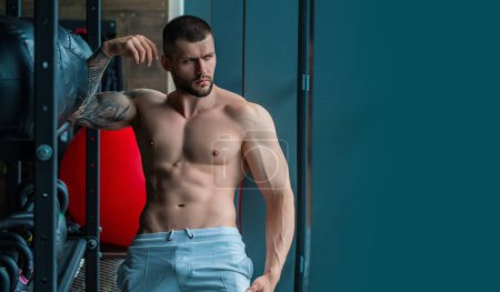 Photo for Sexy muscular man pumps his muscles and lifts dumbbells in gym. Strong fit man exercising with dumbbells. Muscular young handsome man lifting weights. Weightlifting and training with dumbbells - Royalty Free Image