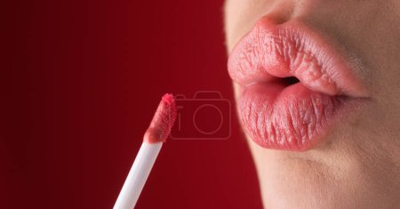 Foto de Mujer cercana aplicando lápiz labial rojo en los labios. Chica sexy aplicado lápiz labial. Los labios rojos pintalabios maquillan. Poner lápiz labial en los labios - Imagen libre de derechos