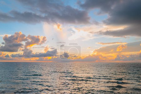 Téléchargez les photos : Ciel nuageux au coucher du soleil sur la mer, lever du soleil sur la plage océanique. Paysage au coucher du soleil dans le ciel après le coucher du soleil. Lever de soleil avec des nuages de différentes couleurs contre le ciel et la mer - en image libre de droit
