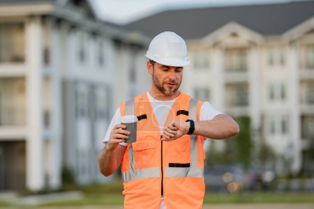 Photo for Engineer drinking take away coffee on break. Builder on site construction. Man worker in hard hat. Construction worker in helmet at construction new home building - Royalty Free Image