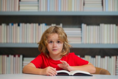 Photo for Little student on school library. Child reading book at school. Nerd pupil studying at school. Clever intelligent schoolboy overwork. Smart child learning to read book - Royalty Free Image