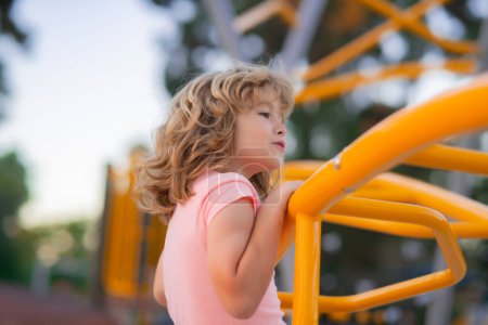 Photo for Cute child boy plays on playground. Kid climbing on playground - Royalty Free Image