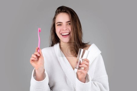 Téléchargez les photos : Jeune femme se brossant les dents. Concept dentaire. Joyeux fille drôle brosser ses dents sur fond isolé. Belle large sourire de jeune femme avec de grandes dents blanches en bonne santé - en image libre de droit