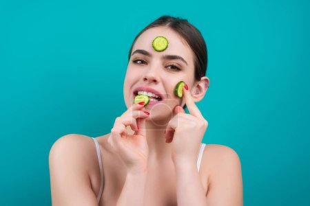 Téléchargez les photos : Woman with facial mask with slices of fresh cucumber on face. Cosmetic procedure. Beauty spa and cosmetology. Spa woman applying facial clay mask. Beauty treatments - en image libre de droit