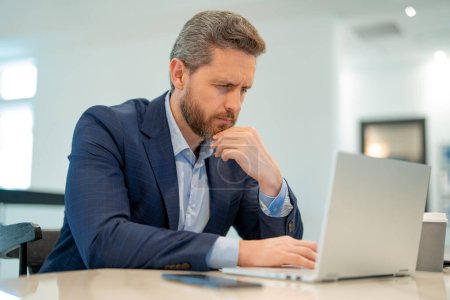 Photo for Serious business man working in office. Handsome business man in casual suit using laptop in office. Business man office worker in formal suit. Office manager ceo businessman using computer - Royalty Free Image