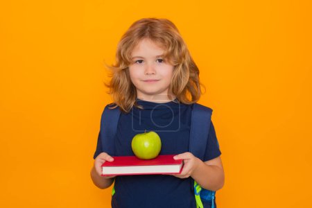 Photo for School children. School pupil. Little student school child isolated on studio background. Portrait of nerd schoolboy with book and apple - Royalty Free Image