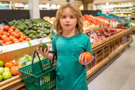 Photo for Healthy food for kids. Portrait of smiling little child with shopping bag at grocery store or supermarket. Child choosing fruit during shopping at vegetable supermarket - Royalty Free Image