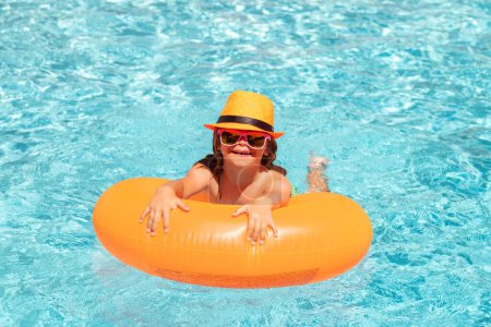 Photo for Child in swimming pool swim on inflatable ring. Water float. Kid boy splashing in swimming pool having fun, leisure activity - Royalty Free Image