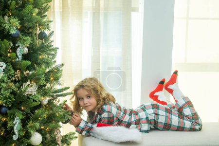 Foto de Niño feliz cerca del árbol de Navidad en casa - Imagen libre de derechos