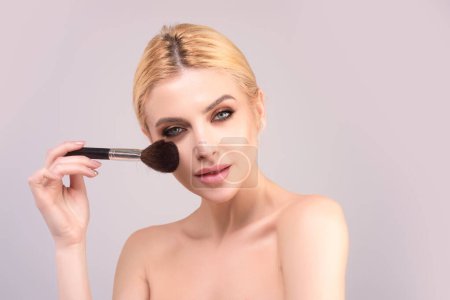 Téléchargez les photos : Beauty girl with makeup brushes. Make up for woman. Girl with makeup brushes near face. Cosmetic brush. Facial Makeup. Female model applying blush powder foundation tone - en image libre de droit