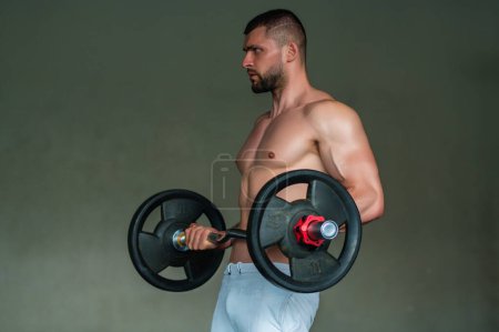 Téléchargez les photos : Muscular man lifting weights at gym. Handsome guy prepare to do exercises with dumbbell - en image libre de droit