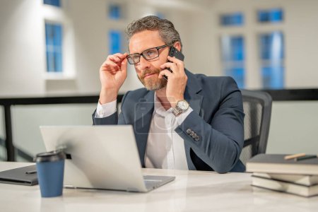 Photo for Business man talking on phone at office workplace. Business man director using laptop. Millennial manager at office workplace. Office workers business people at office - Royalty Free Image