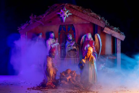 Téléchargez les photos : Naissance de Noël de Jésus. Une scène de Noël avec l'enfant Jésus, Marie et Joseph dans la crèche. Bethléem. Religieux chrétien. La Bienheureuse Vierge Marie, saint Joseph et l'enfant Jésus - en image libre de droit
