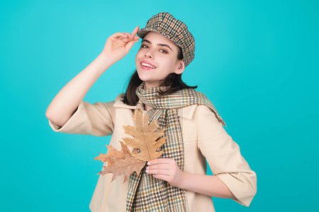 Foto de Moda mujer retrato de otoño con hojas de arce amarillo sobre un fondo aislado estudio. Retrato de otoño de mujer alegre con hojas de otoño con boina y bufanda cálida de otoño - Imagen libre de derechos