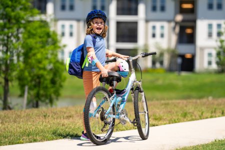 Photo for Child on bicycle. Boy in a helmet riding bike. Little cute caucasian boy in safety helmet riding bike in city park. Child first bike. Kid outdoors summer activities. Kid on bicycle. Boy ride a bike - Royalty Free Image