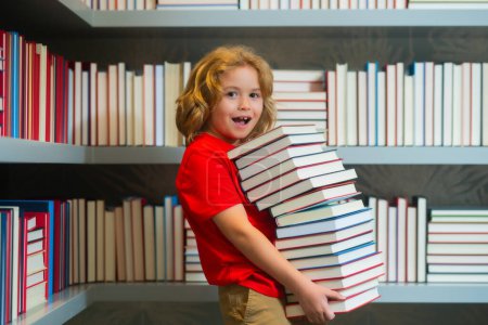 Photo for Funny surprised school kid. Child pupil reading book in a book store or school library. Kid study read - Royalty Free Image