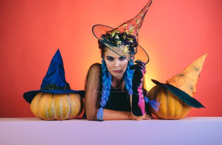 Foto de Glamour Fashion Sexy Vampire Lady con disfraz de bruja. Mujer con sombrero de bruja y traje señalando la mano - mostrando productos - Imagen libre de derechos