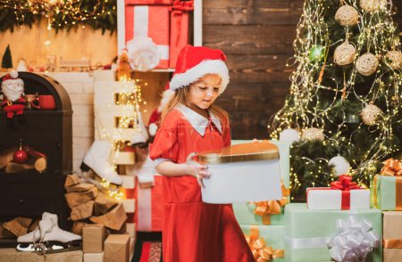 Photo for Happy child with Christmas gift. New year kids. New year concept. Child with a Christmas present on wooden house background - Royalty Free Image