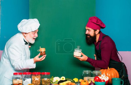 Téléchargez les photos : Deux hommes en uniforme de chef approuvant le service de restauration. Restaurant cuisine drôle, chefs et cuisiniers - en image libre de droit