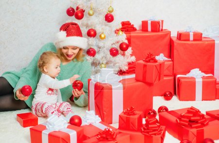 Téléchargez les photos : Joyeux Noël et bonne année. Maman et fille décorent le sapin de Noël. Famille aimante de Noël. Vacances de célébration et convivialité près de l'arbre - en image libre de droit