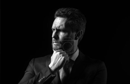 Téléchargez les photos : Portrait d'homme d'affaires debout sur fond noir, isolé. Homme d'affaires mature pensant, gros plan visage - en image libre de droit