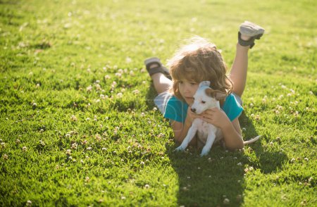 Photo for Hug new friends. Child boy took puppy from shelter. Adopted animal. Small cute pet finds home. Puppy gratefully licks a boys face. Happy kids emotions concept - Royalty Free Image