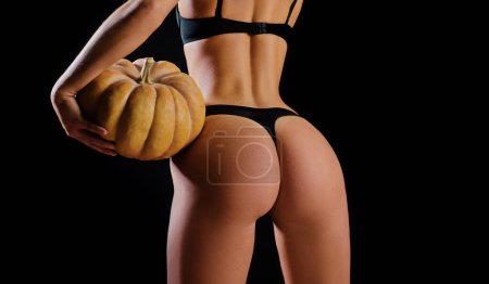 Téléchargez les photos : Halloween, pumpkin butt. Erotica and underwear concept. Sensual girl, nude woman, naked body. Sexy female back with muscular body - en image libre de droit